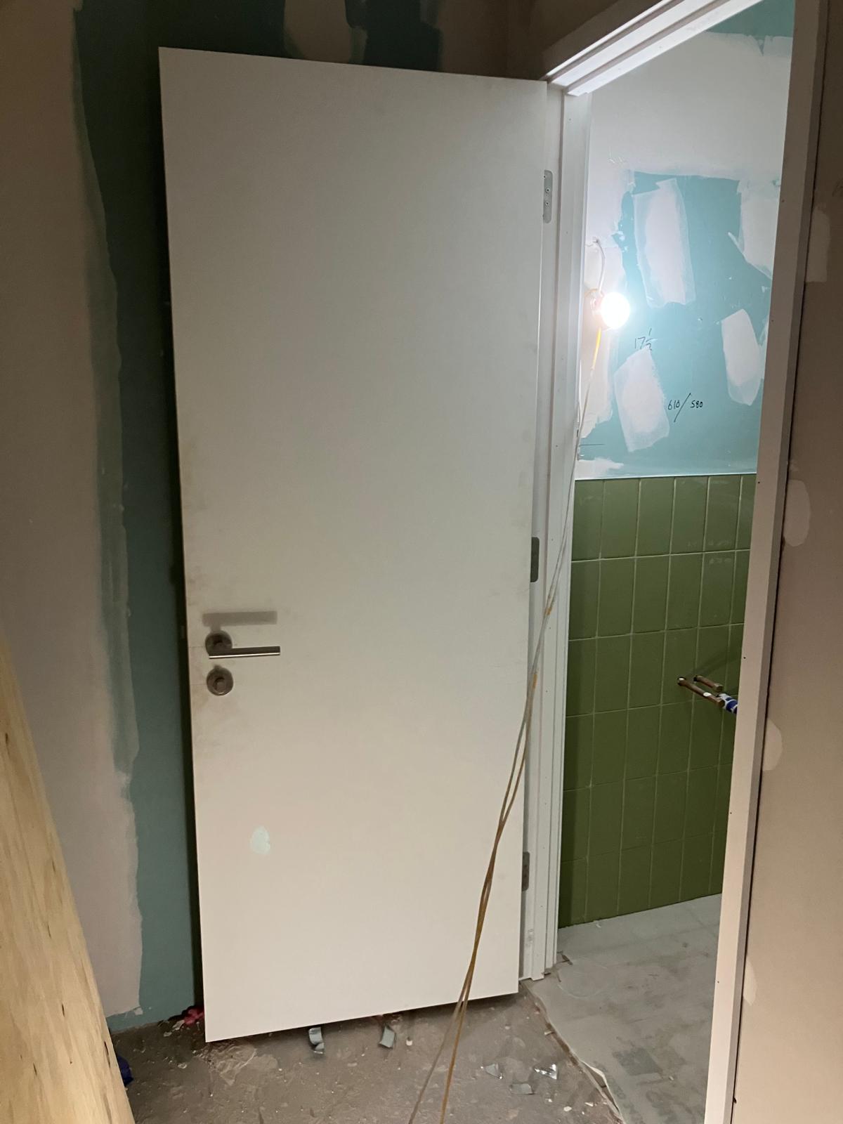 WC door installation and green wall tiling